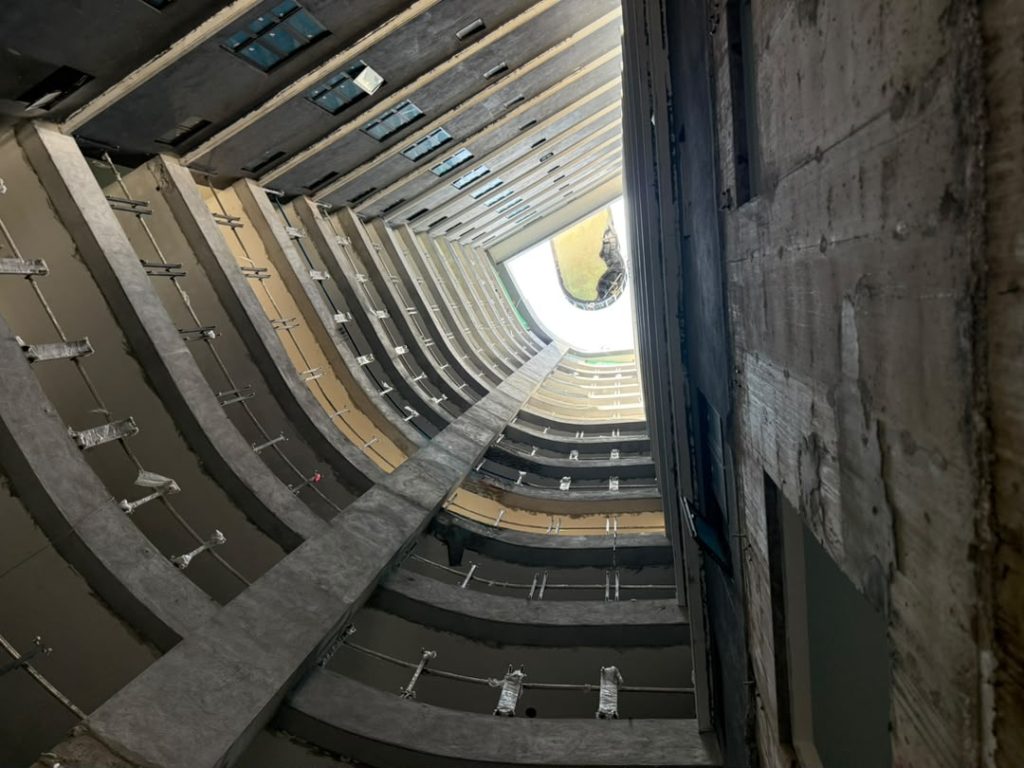 View upward through D’IMMERSIONE building void during Hydro One® composite pool tower-crane installation to Level 4.